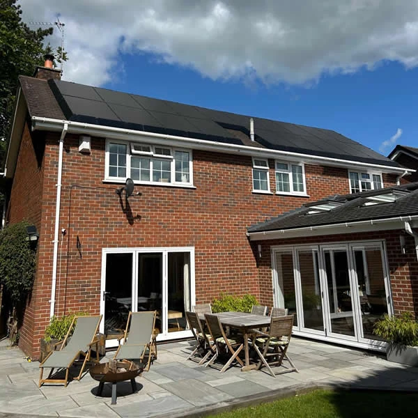 A real UK home with black solar panels overlooking its garden and patio