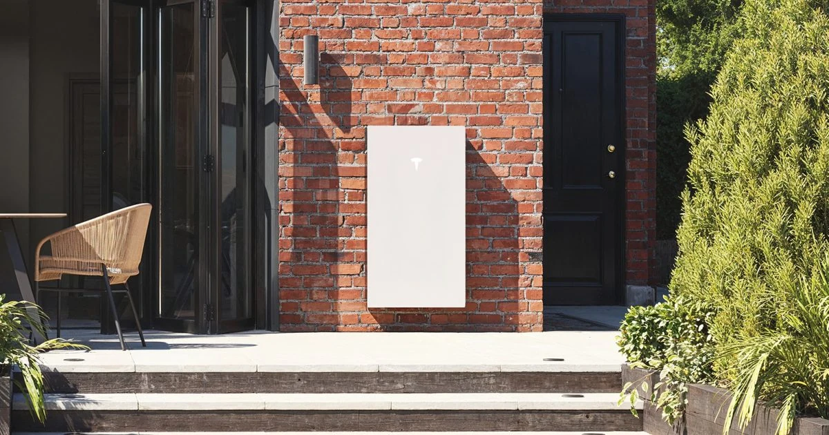 Tesla Powerwall installed neatly on an exterior brick wall, with concealed cable routing
